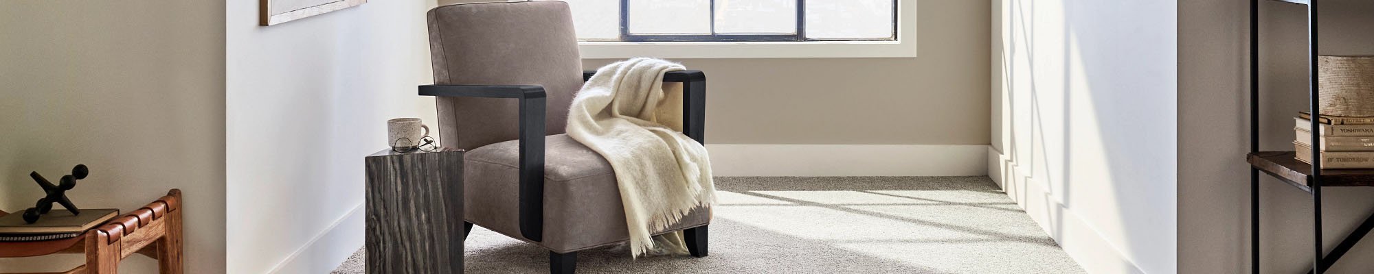 Gray armchair near window in a room with gray carpet from Carpet Villa in Grand Rapids, MI